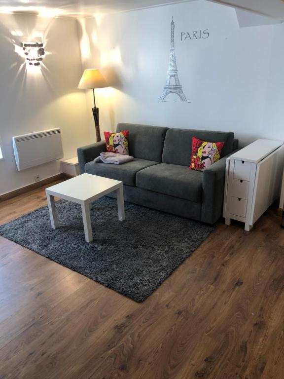 a living room with a couch and a table at Sleep in Paris - Chessy in Chessy