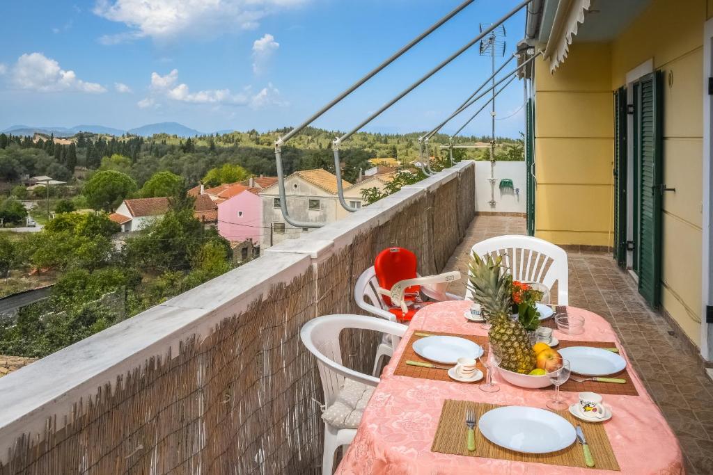 a table with plates of food on a balcony with a view at Modern flat with beautiful views in south of Corfu in Lefkimmi