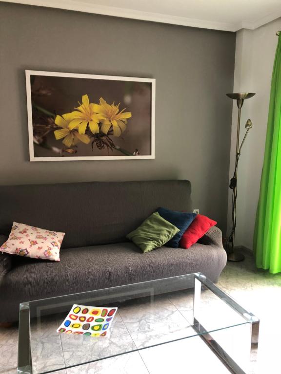 - un salon avec un canapé et une photo sur le mur dans l'établissement Peso de la Harina - piso completo, à Jaén