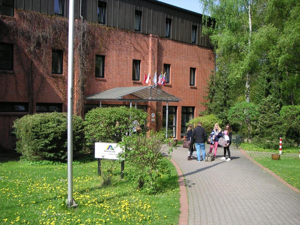 un grupo de personas caminando por una acera en frente de un edificio en Jugendherberge Bonn, en Bonn