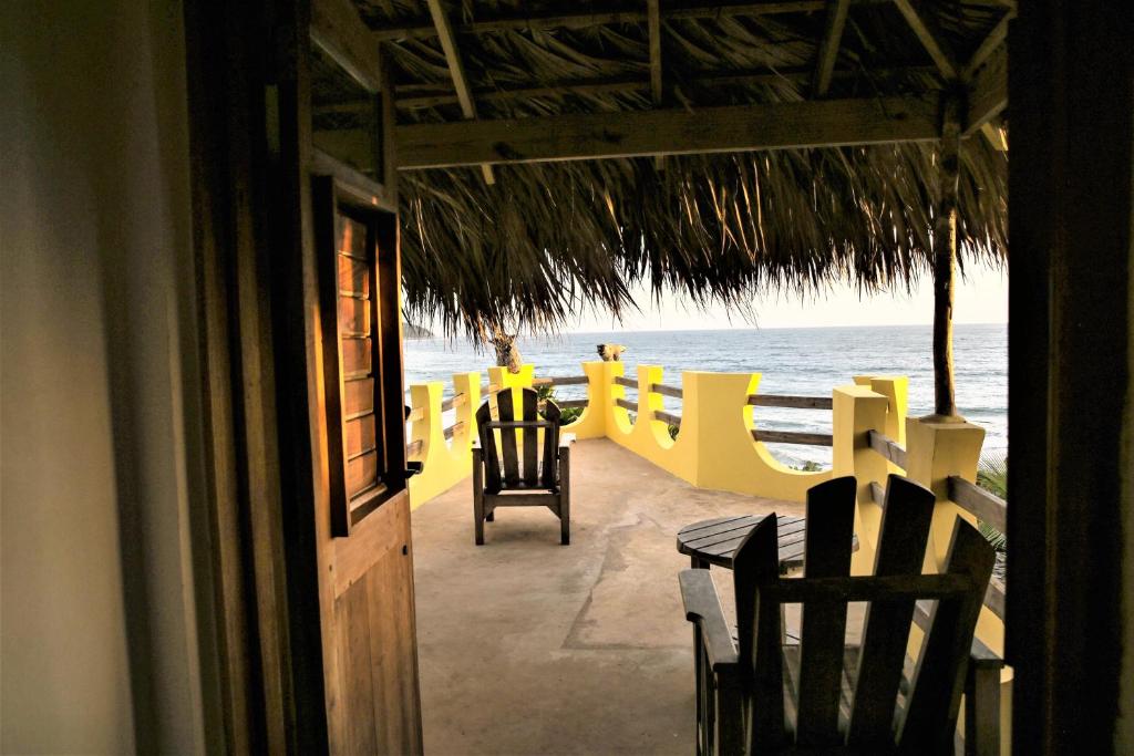 a room with a table and chairs and the ocean at KuDehya Guesthouse in Treasure Beach