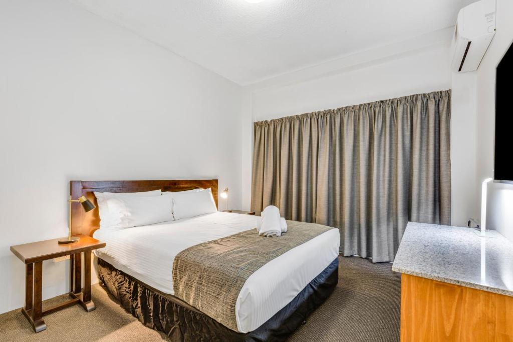 a hotel room with a bed and a window at Rockhampton Riverside Central Hotel Official in Rockhampton