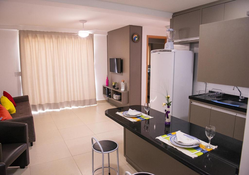 a kitchen and living room with a counter top at Flat Esmeralda in Natal