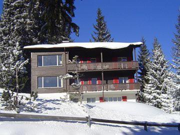 a house with a deck in the snow at Montalin (451 Ti) 1. Stock in Valbella