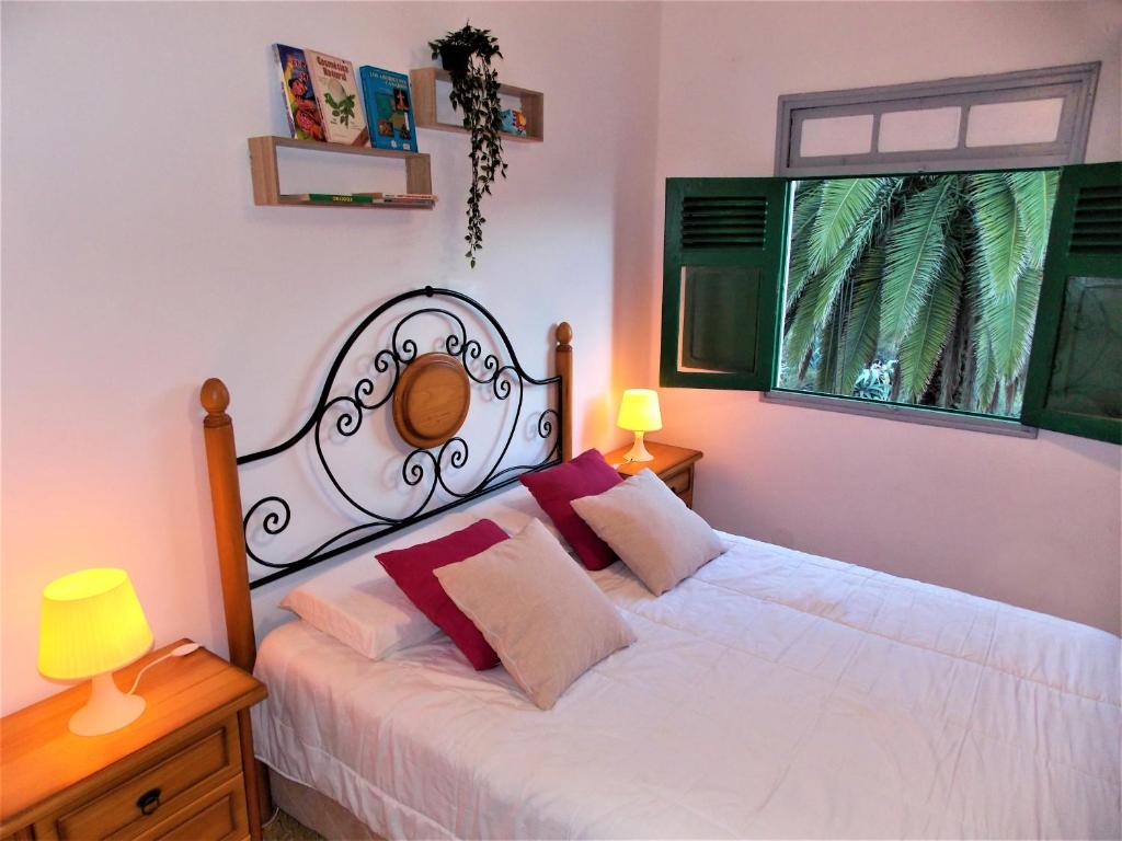 1 dormitorio con cama blanca y ventana en Casa Fasnia Nature, en Fasnia