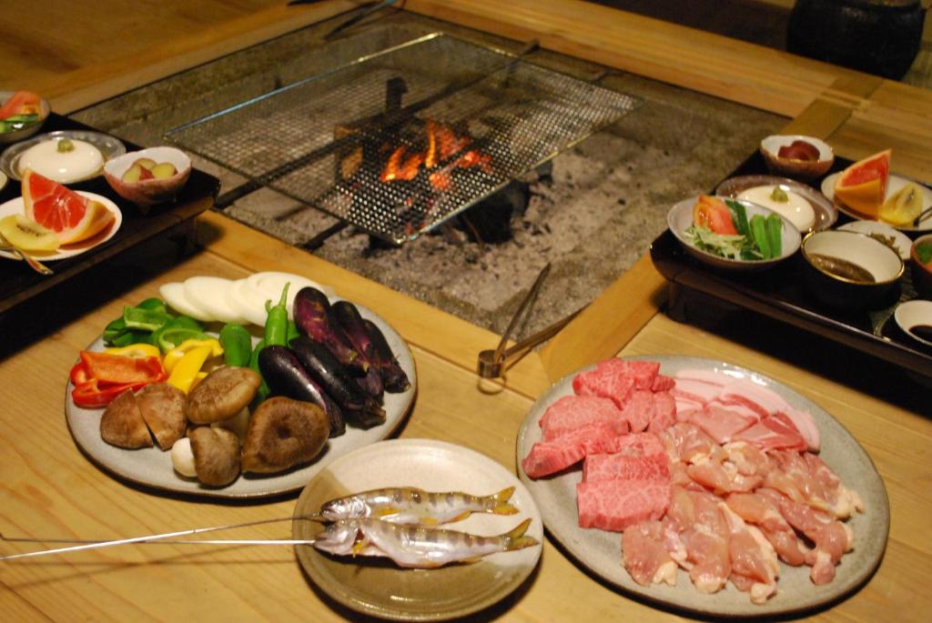 a table topped with plates of food next to a grill at Goemon Kyoto Japan in Kyoto