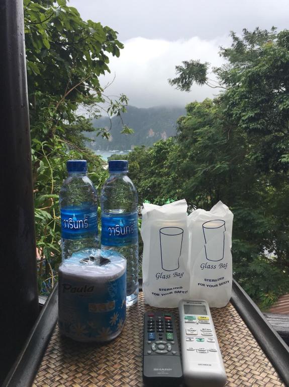 a table with two bottles of water and a remote control at Phi Phi Green Hill Resort in Phi Phi Don