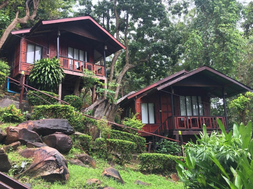 two bamboo cabins in a forest with rocks at Phi Phi Green Hill Resort in Phi Phi Don