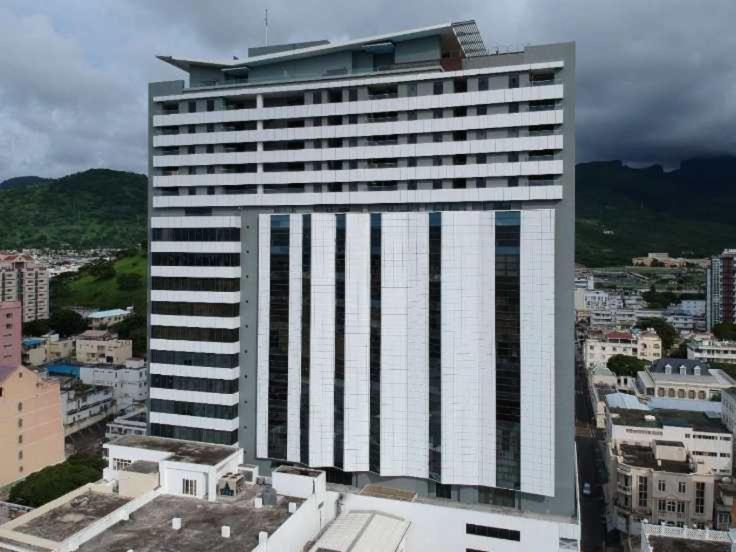 un edificio alto con muchas ventanas en una ciudad en Sea & City View Luxury Apartment en Port Louis