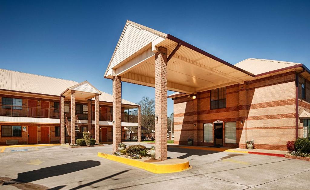 un grand bâtiment avec un auvent dans un parking dans l'établissement Best Western Executive Inn, à Marshall