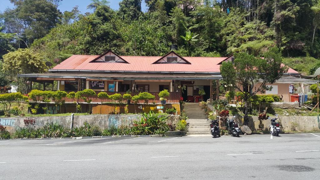 a building with two motorcycles parked in a parking lot at ALORA BUDGET Inn in Tanah Rata