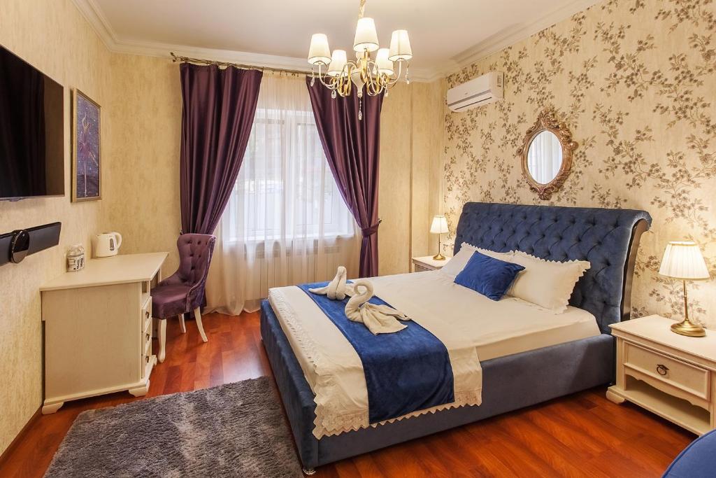 a bedroom with a bed and a desk and a window at Deja Vu Apart-Hotel in Pyatigorsk