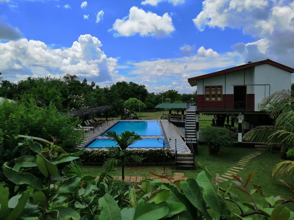 a house with a swimming pool in the yard at Eco Hotel Black & White - Anuradhapura in Mihintale