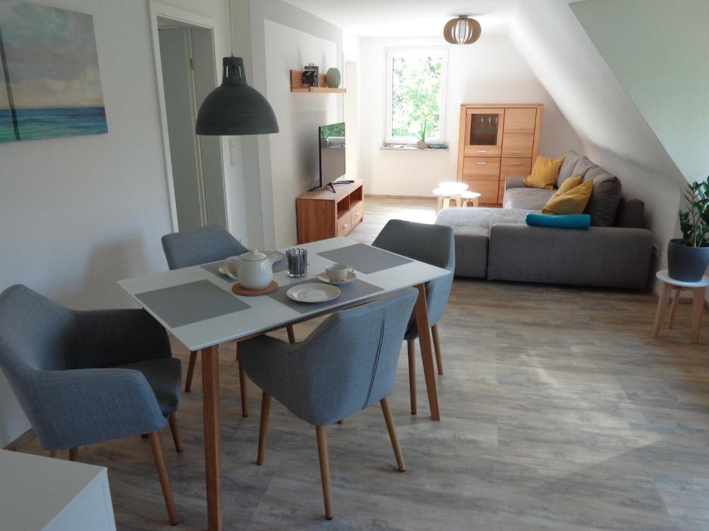 ein Wohnzimmer mit einem Tisch, Stühlen und einem Sofa in der Unterkunft Ferienwohnung Dawe in Göttingen