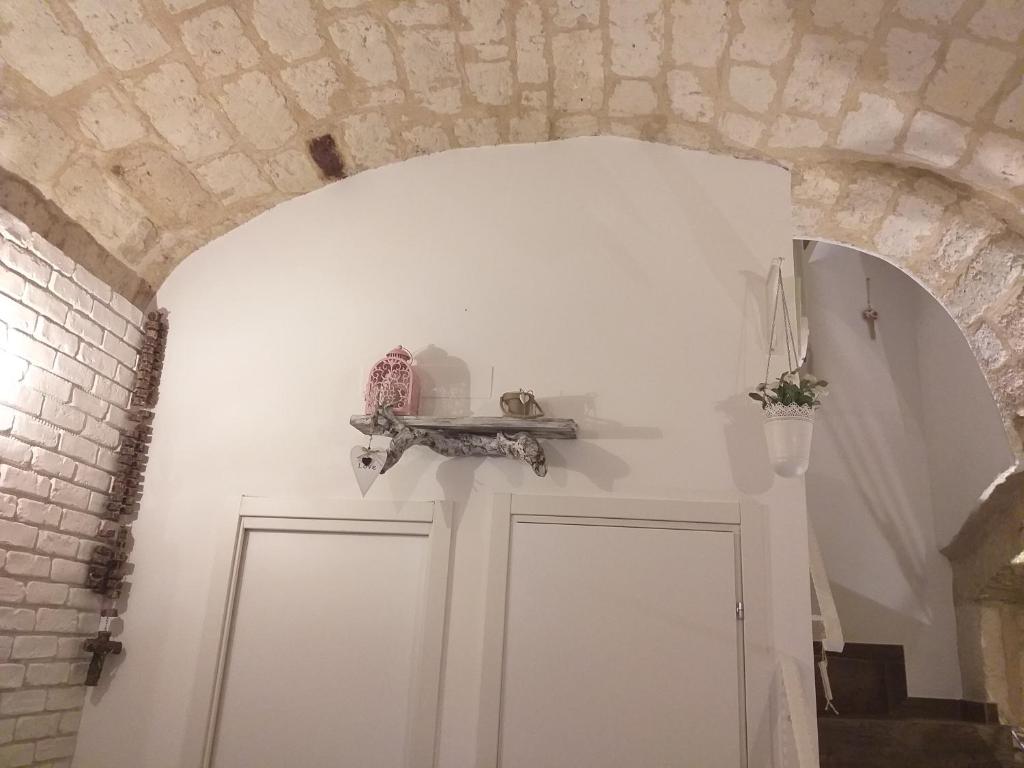 Habitación con 2 puertas blancas y una pared de ladrillo. en B&B La Maison Del Borgo Antico, en Bari