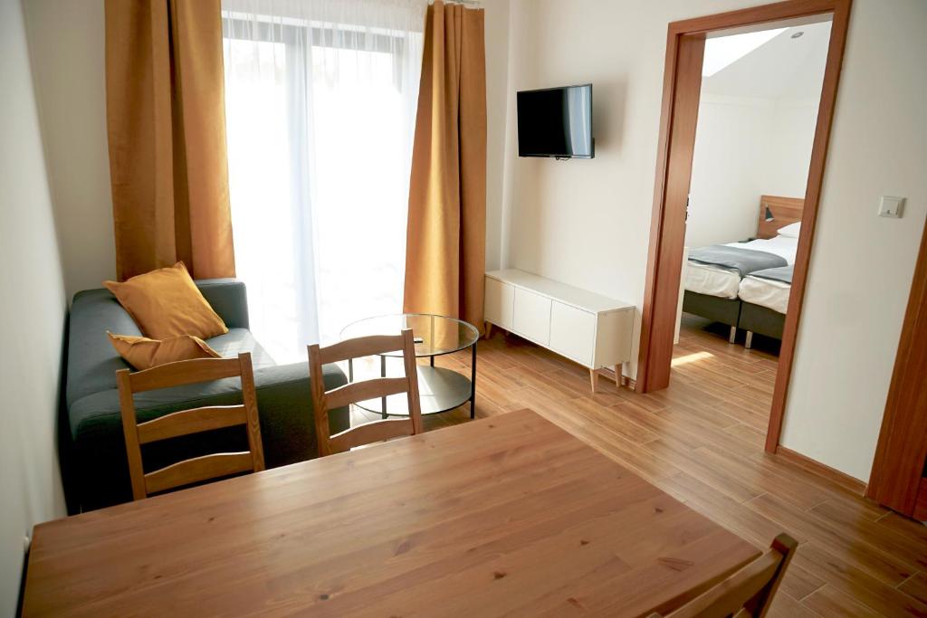 een woonkamer met een tafel, een bank en een spiegel bij Simar in Czeladź
