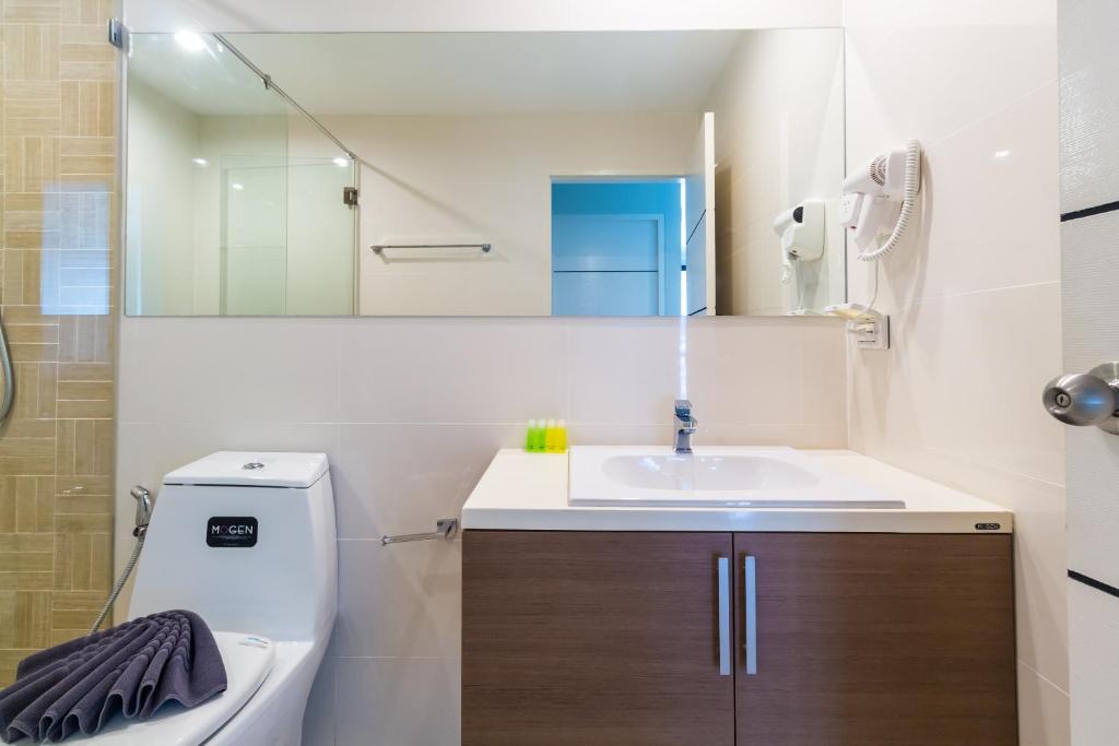 a bathroom with a sink and a toilet and a mirror at Apartments at The Bliss Condo by Lofty in Patong Beach