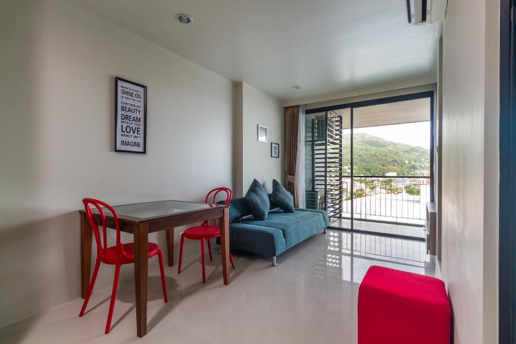 a living room with a table and chairs and a couch at Apartments at The Bliss Condo by Lofty in Patong Beach