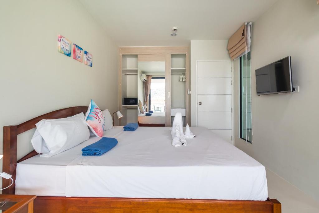 a bedroom with a large white bed and a television at Apartments at The Bliss Condo by Lofty in Patong Beach