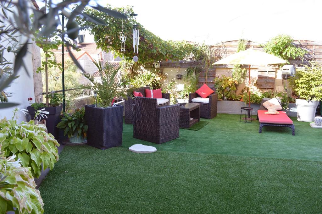 une terrasse avec des chaises et des plantes sur l'herbe dans l'établissement Les remparts d'Angoulême, à Angoulême