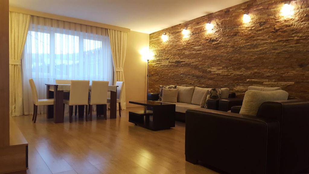 Apartment Rustaveli 1 في تبليسي: غرفة معيشة مع أريكة وغرفة طعام