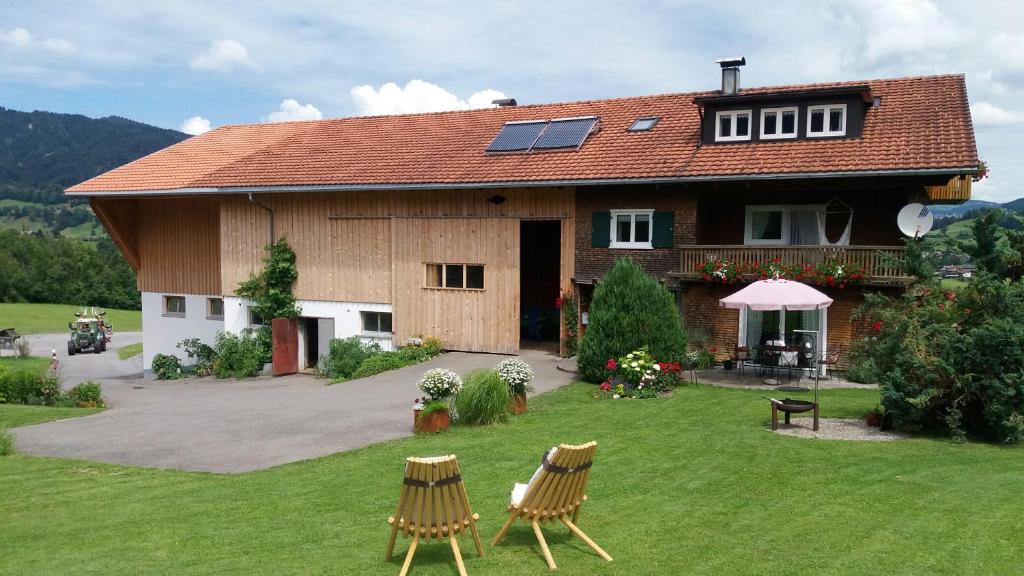 a house with two chairs in the yard at Familienbauernhof Köss Schertler in Egg