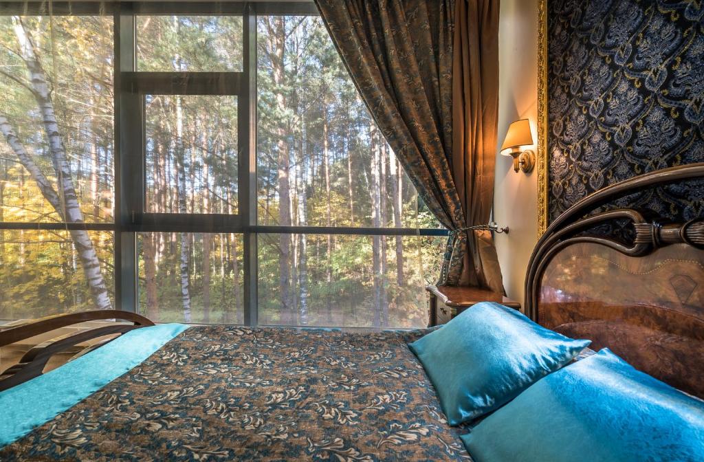 um quarto com uma cama e uma grande janela em Baltazaras em Vilnius