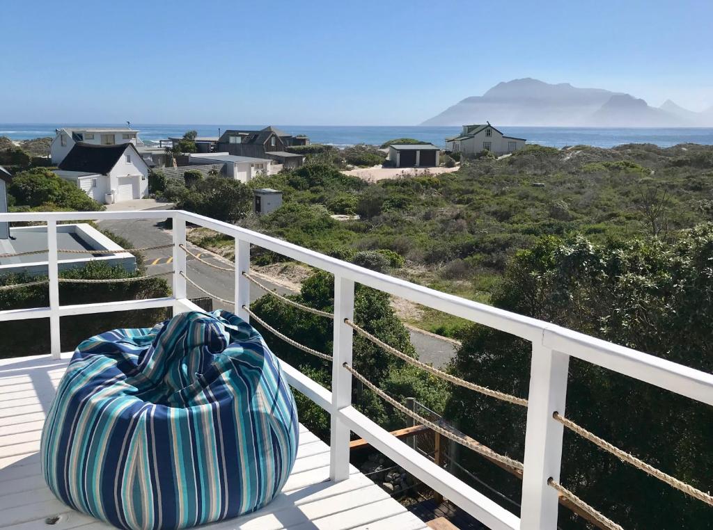 a blue and white pillow sitting on a porch overlooking the ocean at Seabreeze in Kommetjie
