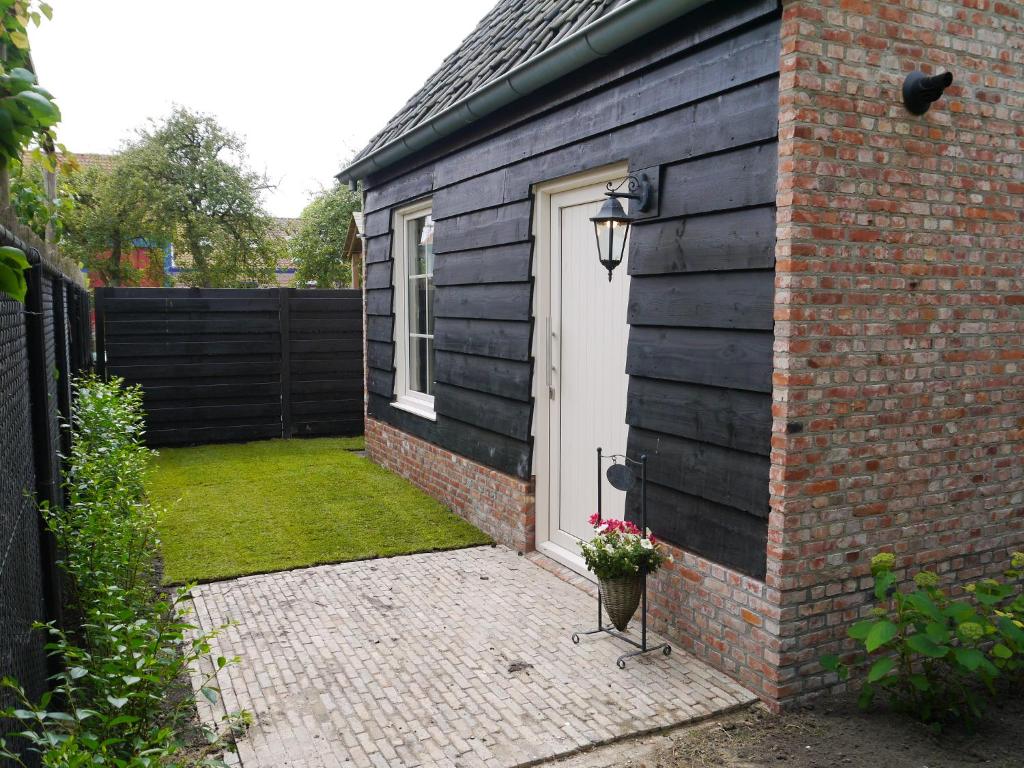 a backyard with a black fence and a white door at Vakantiehuis Hof Molenzicht in Oostkapelle