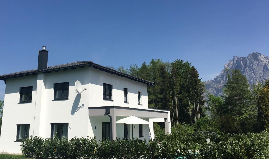 una casa blanca con una montaña en el fondo en Wohlfühlapartments Steiner, en Altmünster