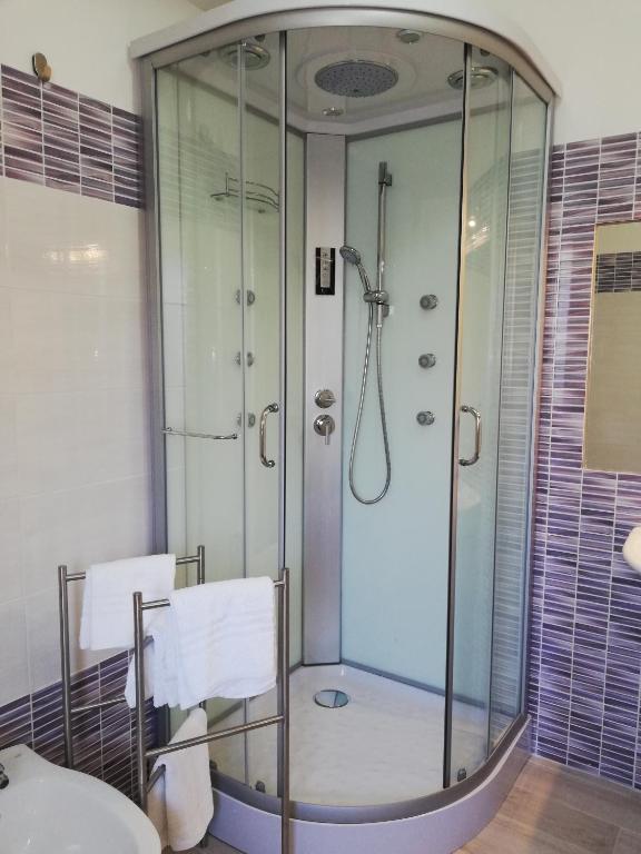 a shower with a glass door in a bathroom at Akron B&B in SantʼAlessio Siculo