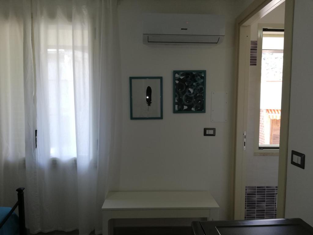 a white room with a window and a bench at Akron B&B in SantʼAlessio Siculo