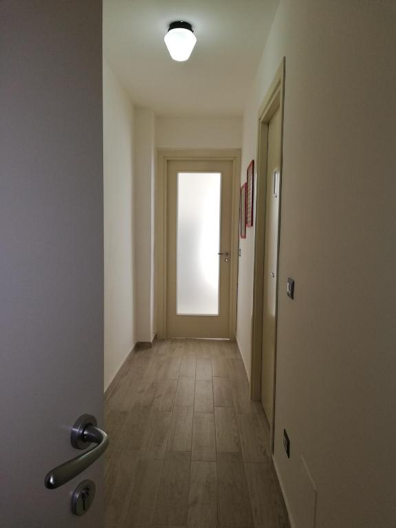 an empty hallway with a door with a light in it at Akron B&B in SantʼAlessio Siculo