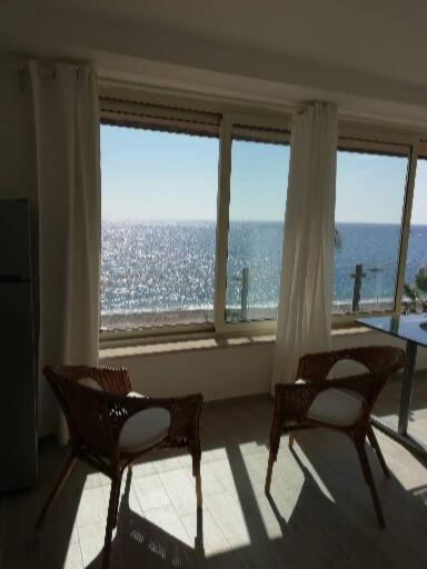two chairs and a table in a room with windows at Akron B&B in SantʼAlessio Siculo