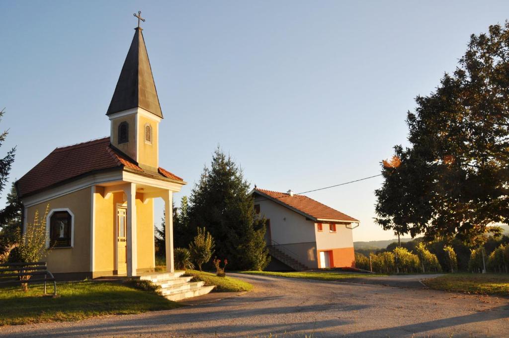uma pequena igreja com um campanário numa estrada em Apartman"KATJA" em Sveti Martin na Muri