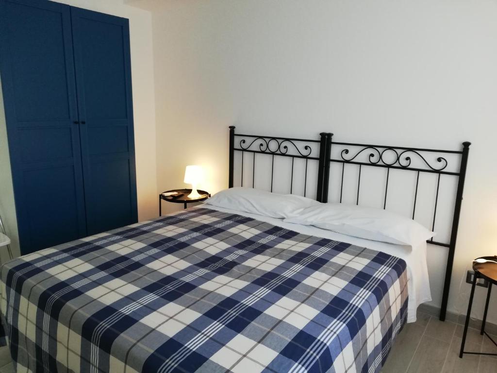 a bedroom with a bed with a blue and white checkered blanket at Akron B&B in SantʼAlessio Siculo