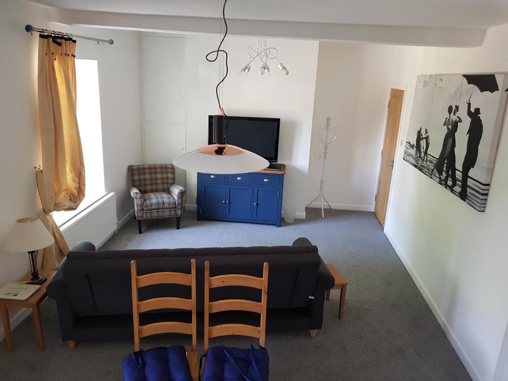 a living room with a couch and a tv at Church View at Plover Cottage Lindley in Huddersfield