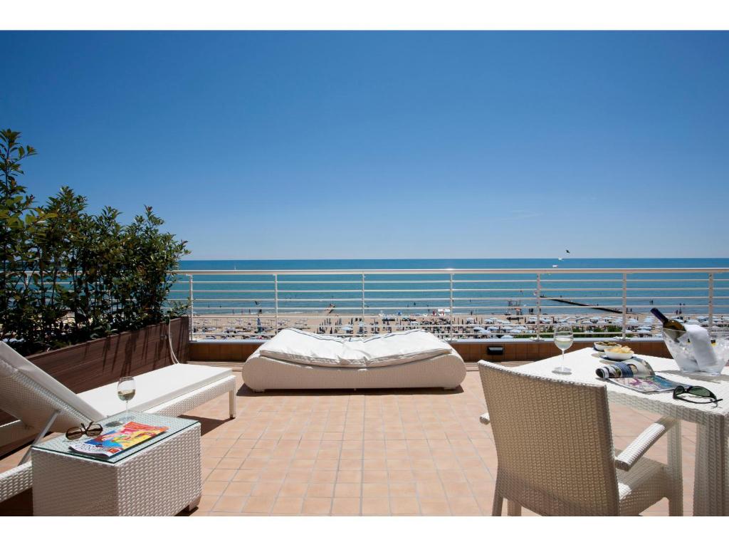 um pátio com vista para a praia e para o oceano em Hotel Aurora em Lido di Jesolo