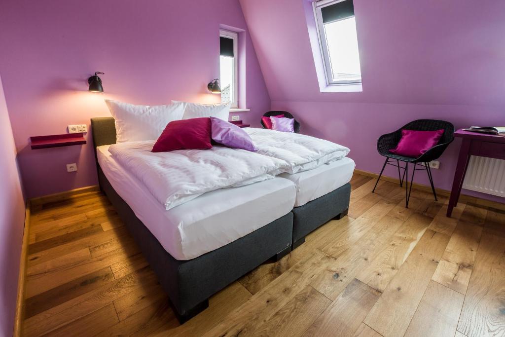 ein Schlafzimmer mit einem großen Bett mit lila Wänden in der Unterkunft Villa Stern in Oldenburg