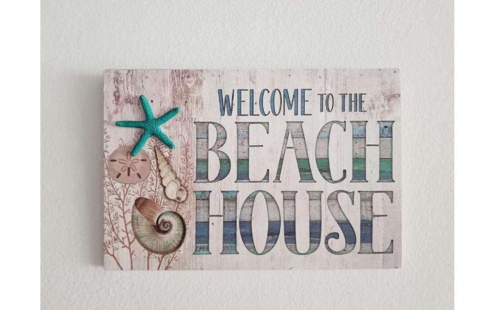 um livro com uma placa que diz bem-vindo à casa de praia em Beautiful Villa at The Rio Mar Beach Resort em Rio Grande