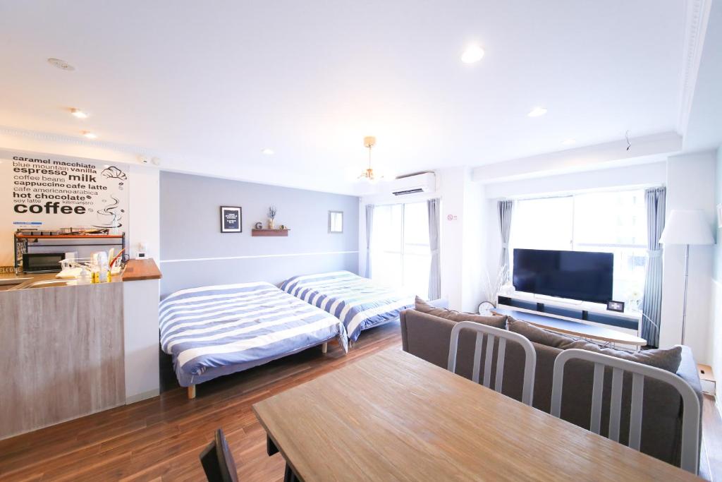 a living room with a couch and a tv at Guest House Re-worth Yabacho1 202 in Nagoya