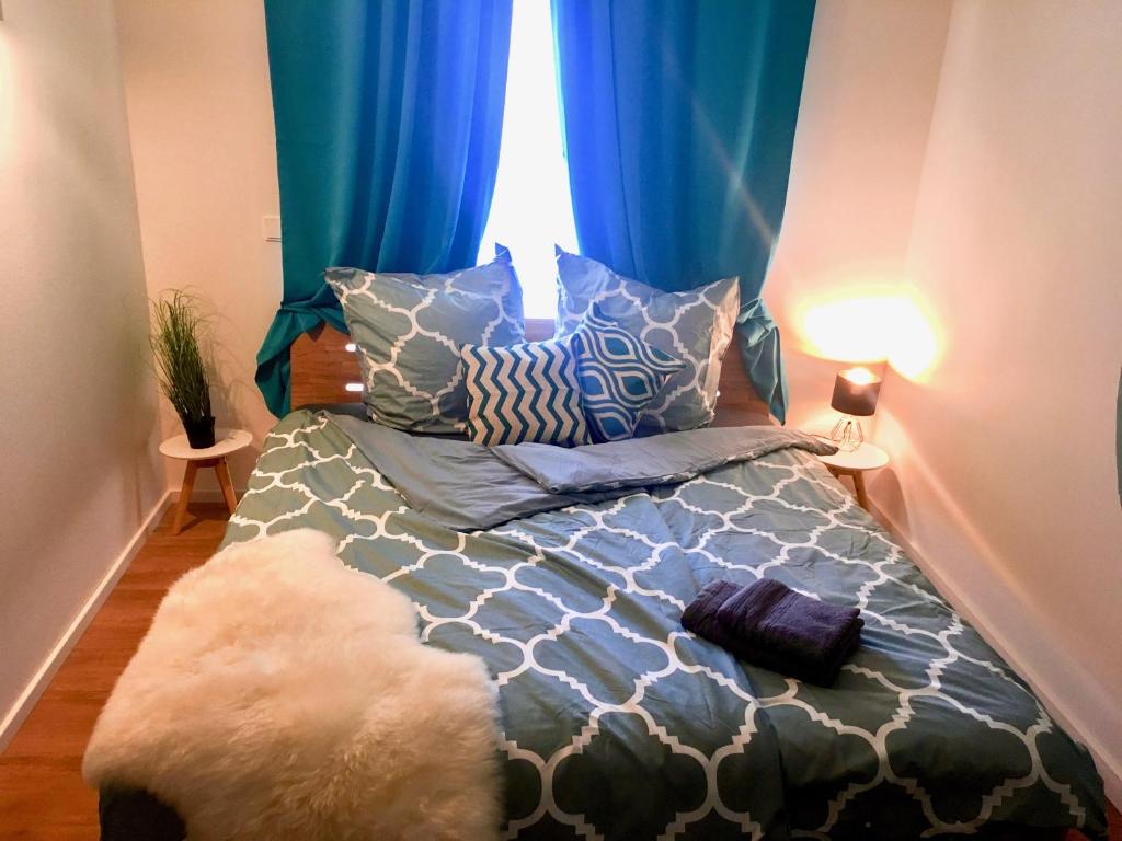 Schlafzimmer mit einem Bett mit blauen Vorhängen und einem Fenster in der Unterkunft 5 Zimmer Loftstylewohnung in Bad Wörishofen in Bad Wörishofen