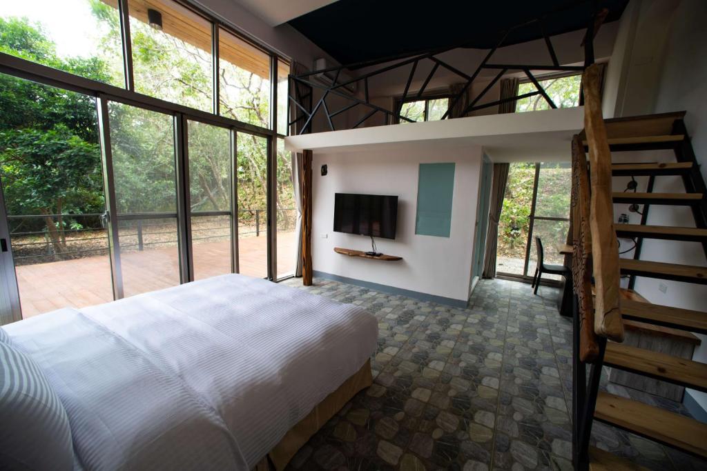 una camera con letto e TV e alcune finestre di Toptai Homestay a Kenting