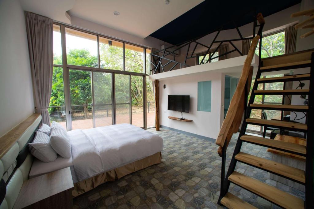 una camera con un letto e una scala in una casa di Toptai Homestay a Kenting