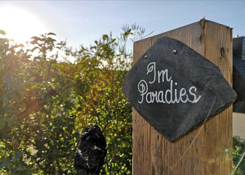 een bordje met de tekst 'ik ben tomaten' op een houten hek bij Ferienwohnung Im Paradies in Momlingen