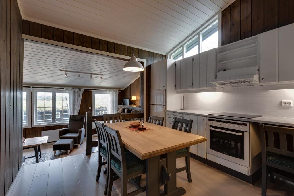 eine Küche und ein Esszimmer mit einem Holztisch und Stühlen in der Unterkunft Bitigrenda G in Beitostøl