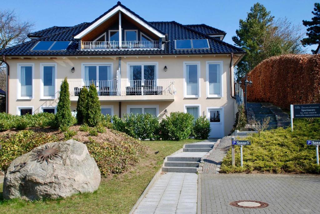 ein großes weißes Haus mit einem Dach in der Unterkunft Villa Sonnenterrasse in Pelzerhaken