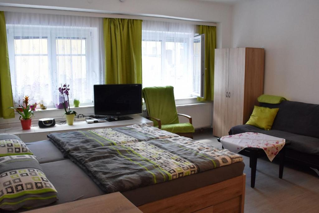 a bedroom with a bed and a living room with a couch at Fam. Graf Privatzimmervermietung in Weitra