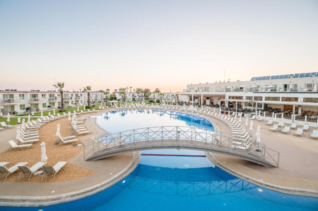 a bridge over a swimming pool in a resort at Sunprime Ayia Napa Suites - Adults Only in Ayia Napa