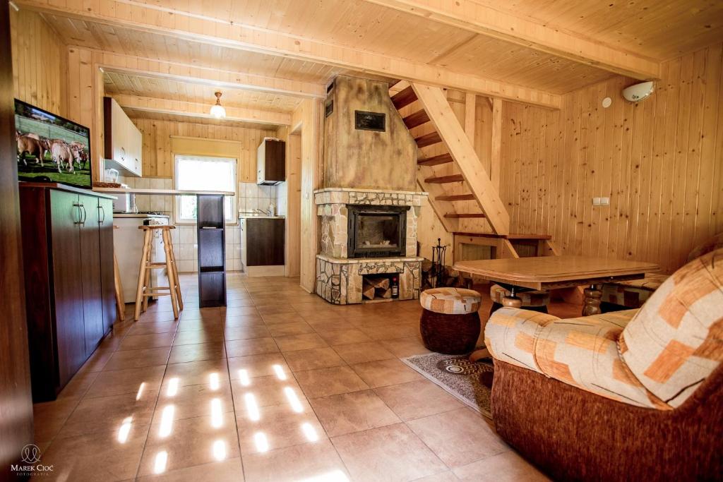 eine Küche und ein Wohnzimmer mit einem Kamin in der Unterkunft Cichy Zakątek in Cisna
